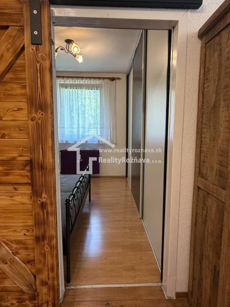 A hallway in a 3-room apartment with sliding doors, wooden decor flooring.