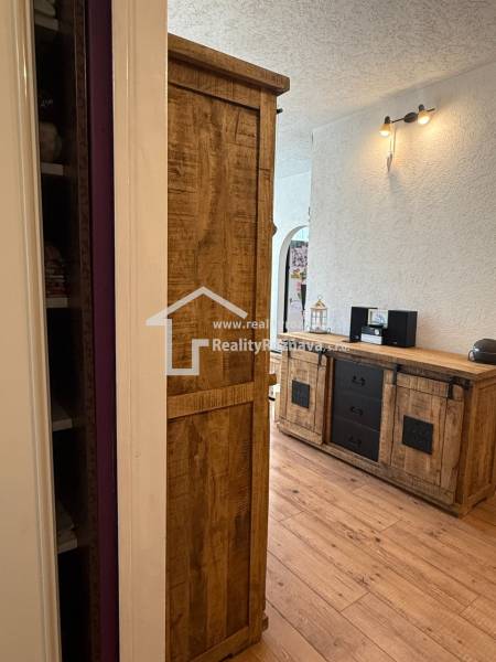 Interior of a 3-room apartment with a wooden decor floor and solid furniture.