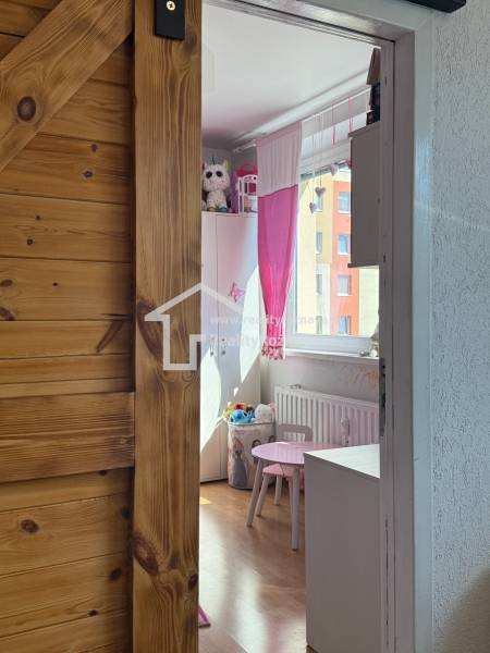 Children's room with light furniture and a wooden decor floor in a 3-room apartment.