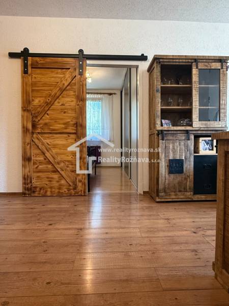 Interior of a 3-room apartment with sliding doors and a wooden decor floor.