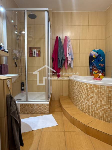 A bathroom with a wood-patterned floor, a shower corner, and a corner bathtub.