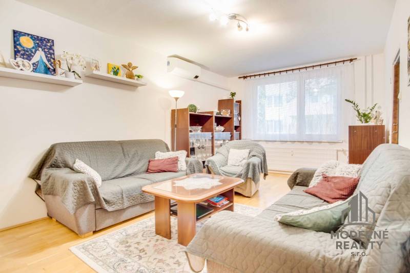 Living room in a 3-room apartment with a wooden decor floor, sofas, and decorations.