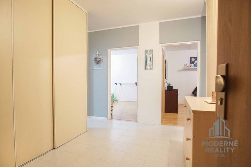 Entrance hall of a 3-room apartment with a large wardrobe and open doors to the rooms.