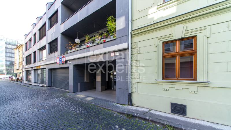 Garages on Jozefská Street in Bratislava - Old Town with stone cladding and vegetation.