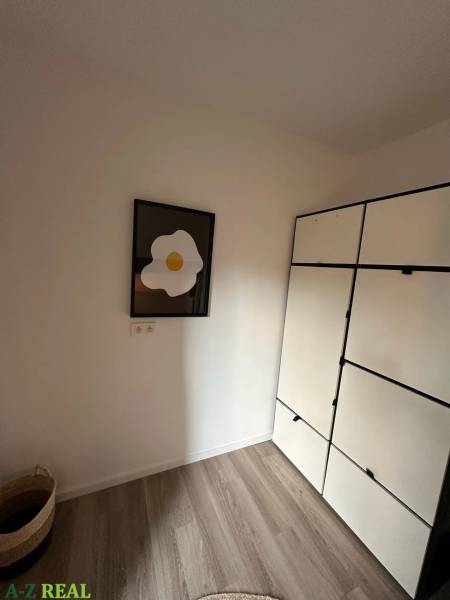 A wardrobe and a painting in a 3-room apartment, floor with wooden decor.