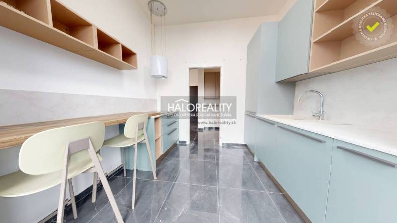 A kitchen with a bar counter, light cabinets, and a gray floor in offices.