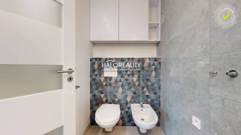 Toilet and bidet, mosaic tiles, gray tiles, storage cabinet, clean office interior.