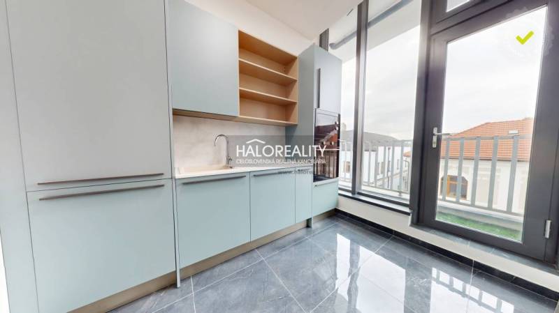 A bright kitchen with modern cabinets and large windows in the offices.