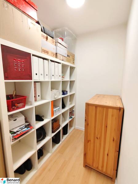Storage space with a shelving unit and a floor with a wooden decor in a 3-room apartment.