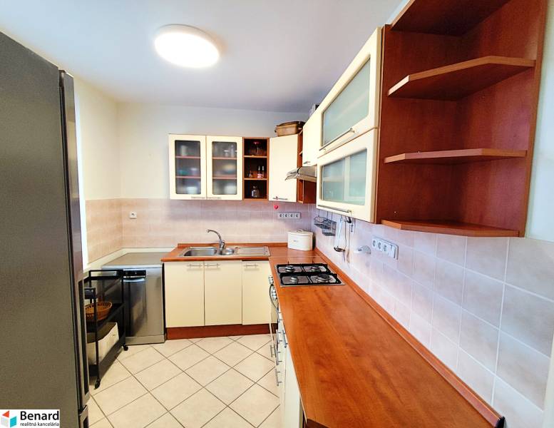 A kitchen with ample storage space in a 3-room apartment, equipped with appliances.