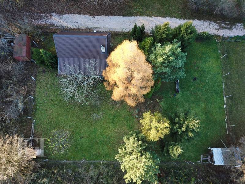 A garden with a cottage in Štitáre surrounded by trees, aerial view.