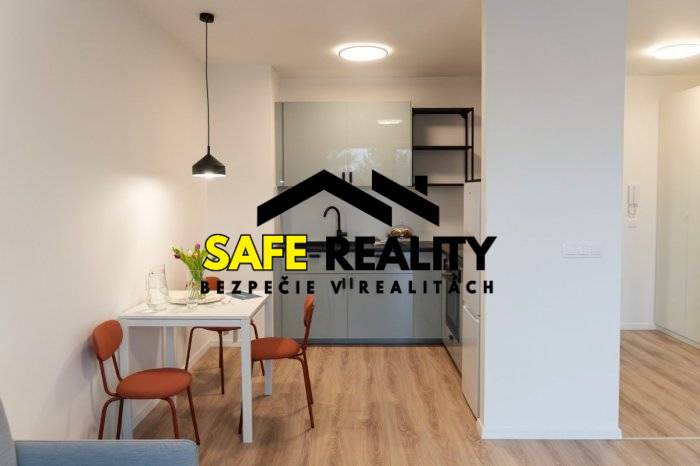 A studio apartment with a wooden decor floor, a dining table, and a kitchenette.