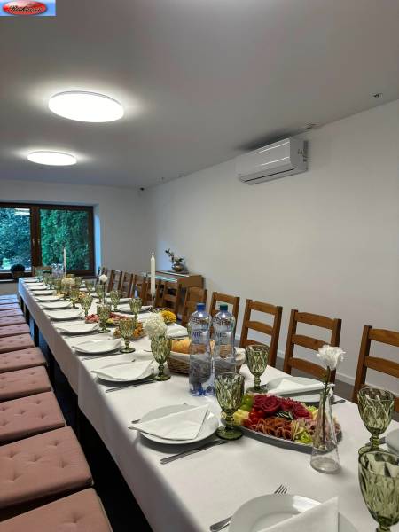 Interior of commercial premises with a long set table and chairs for a celebration.