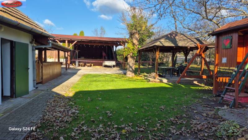A courtyard with shelters and green area in commercial premises on Park and Main Road, Veľké Ludince.