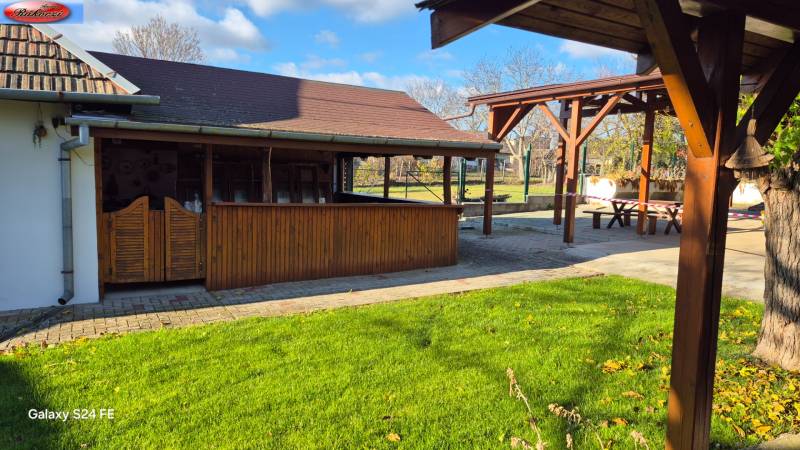 Garden with a gazebo near commercial premises in Veľké Ludince, park and main road.