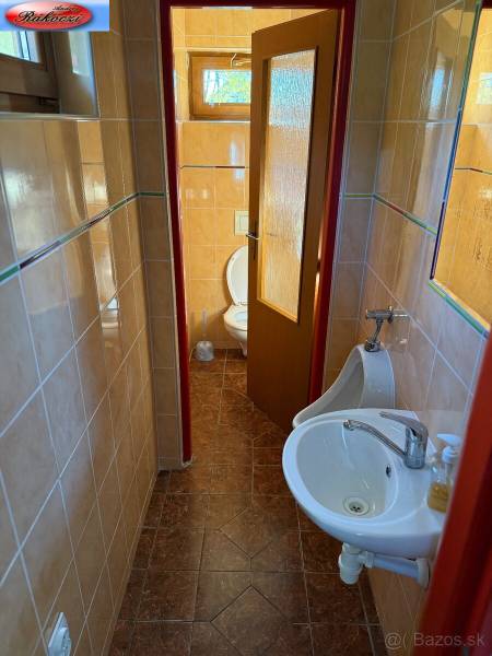 A restroom with a sink and a urinal in commercial premises with ceramic tiles.