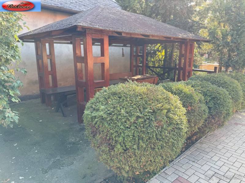 A wooden gazebo surrounded by greenery near commercial premises on Park and main road, Veľké Ludince.