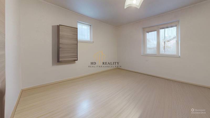 An empty room with a wooden floor in a family house.
