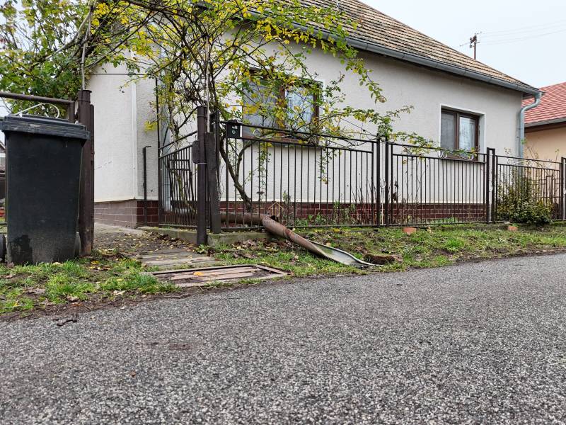 A family house in Hokovce with a garden, a road, and a trash bin by the fence.