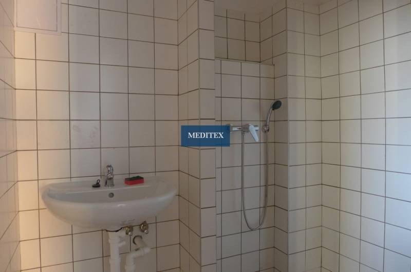 Bathroom with a shower and a sink, tiled with white tiles, in the object Warehouses and halls.