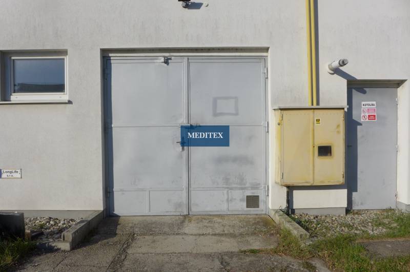 Warehouses and halls in Bratislava - Nové Mesto with gray doors and equipment on the facade.
