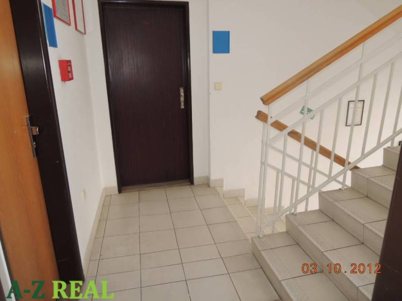 Stairs and doors in offices, with tiles and railings on the stairs.