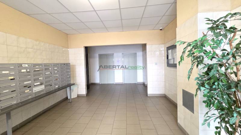 A hallway with mailboxes and an entrance to the elevators in a residential building.