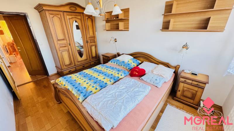 A bedroom with antique furniture and a wooden decor floor in a 4-room apartment.