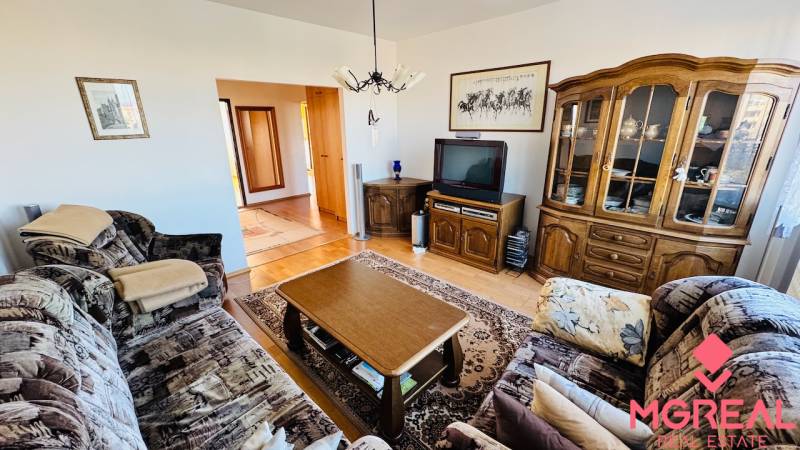 Living room with a sofa set, TV, cabinet, and wooden decor flooring in a 4-room apartment.