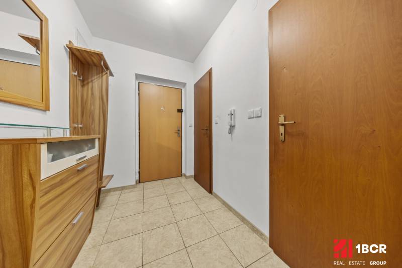 Entrance hallway in a 2-room apartment with wooden furniture and tiles.
