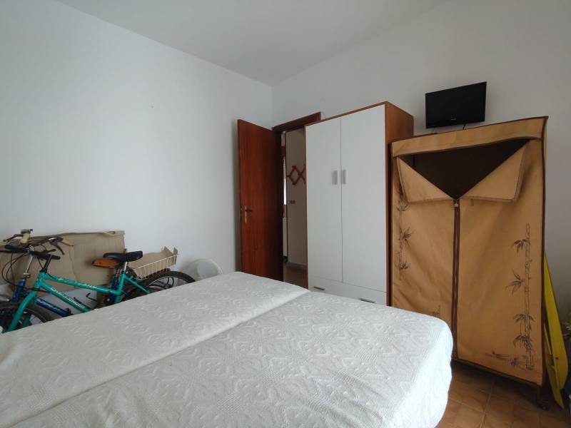 A bedroom in a 3-room apartment with a bed, wardrobes, and a bicycle.