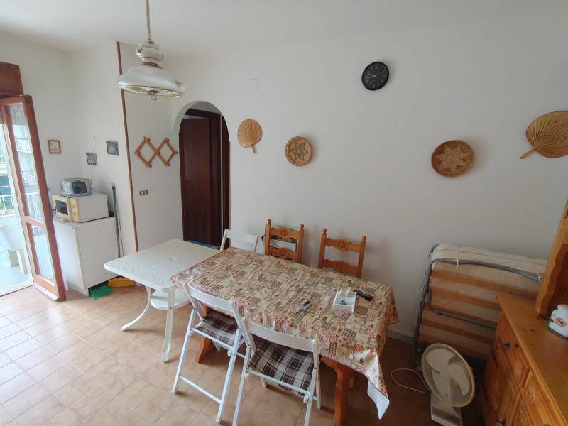 Dining room in a 3-room apartment with a tiled floor, decorative baskets, and wooden furniture.