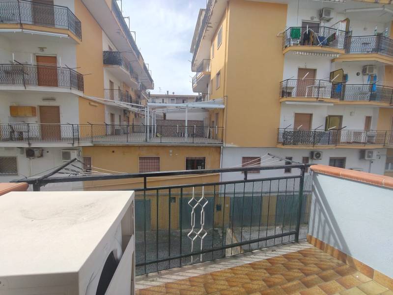A balcony with a view of apartment buildings on 1 Maggio Street in Scalea, a 2-room apartment.