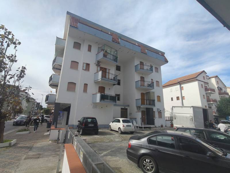 Apartment building in Scalea on 1 Maggio Street with surrounding cars and pedestrians.