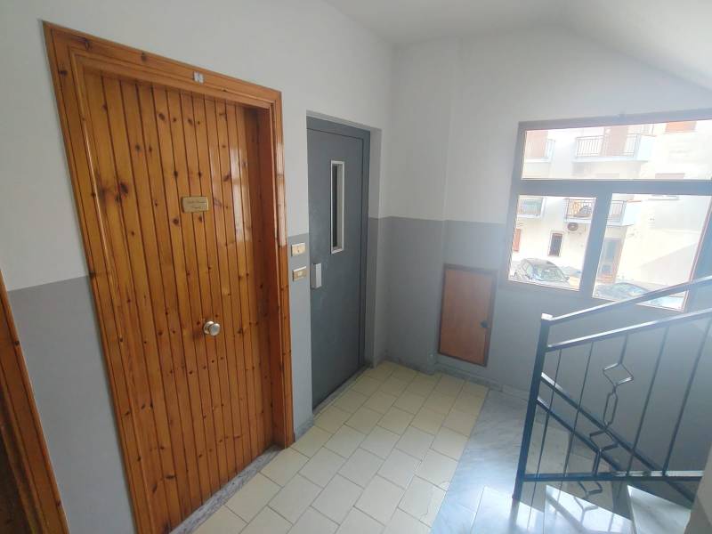 Staircase in a 2-room apartment with wooden doors and a window.