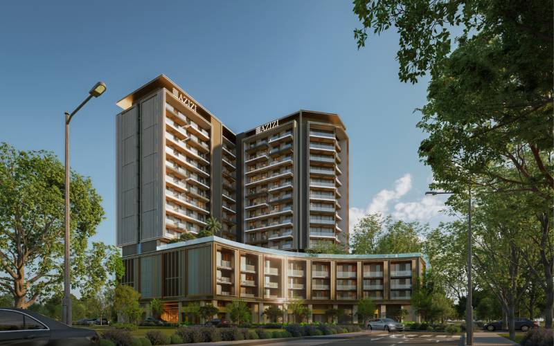 A high-rise building in Downtown Jabel Ali surrounded by greenery and cars on the road.