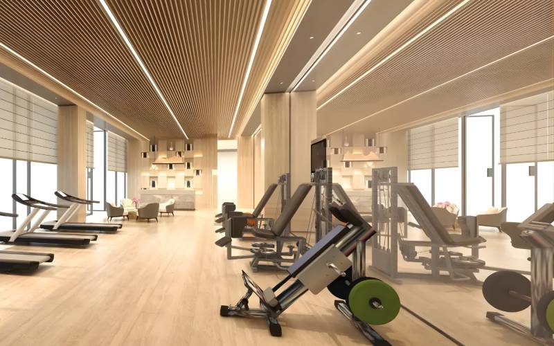 Interior of a gym with sports equipment and wood-patterned flooring.