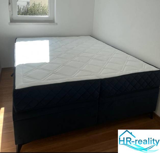 Bedroom in a 3-room apartment with a comfortable mattress and a floor with a wooden decor.