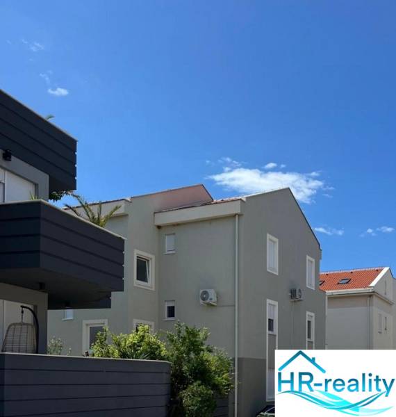 The exterior of apartment buildings in Novalja, ideal for a 3-bedroom apartment, clear sky.