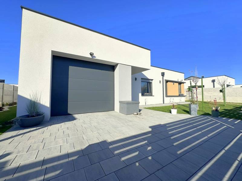 A family house in Mosonmagyaróvár with a clean facade, terrace, and landscaped garden.