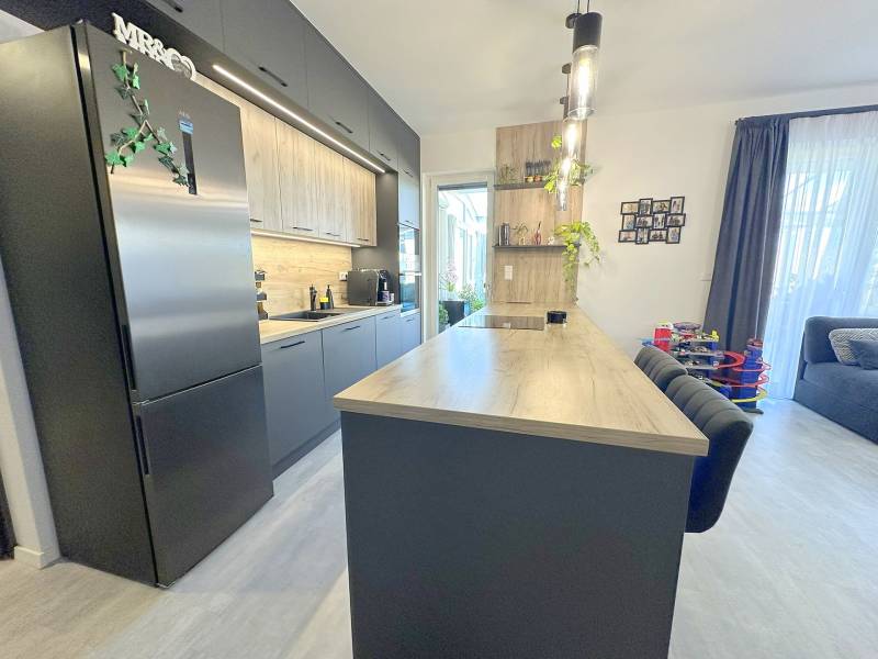 A kitchen in a family house with a wooden decor floor, bright and spacious.