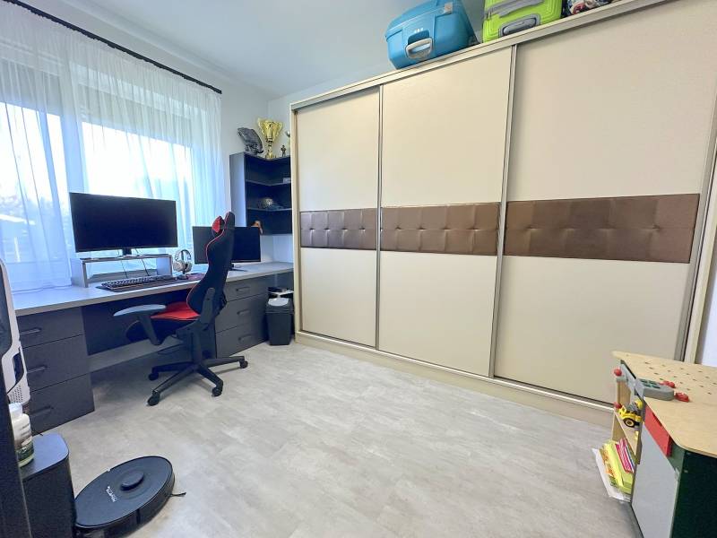 A workspace in a family house with a computer desk, chair, and built-in wardrobe.