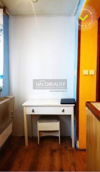 A desk in a studio apartment with a wooden decor floor.