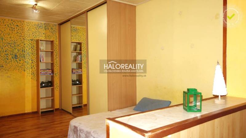 Interior of a 1-room apartment with colorful walls, a mirrored wardrobe, and a floor with a wooden decor.