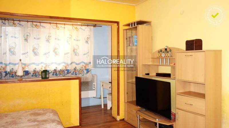 Interior of a 1-room apartment with a wooden decor floor and yellow walls.
