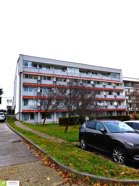 Apartment building on Podbrezovská Street in Bratislava - Rača, with adjacent parking spaces.