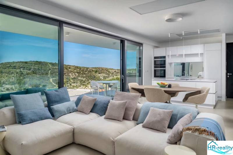 Spacious living room in a holiday apartment with a view, comfortable sofa, and kitchen.