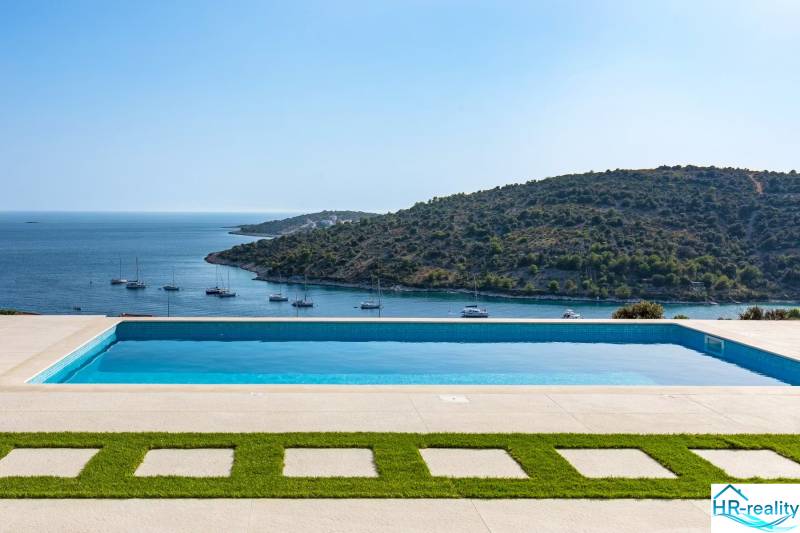 A pool with a view of the sea and yachts in Rogoznica near a vacation apartment.