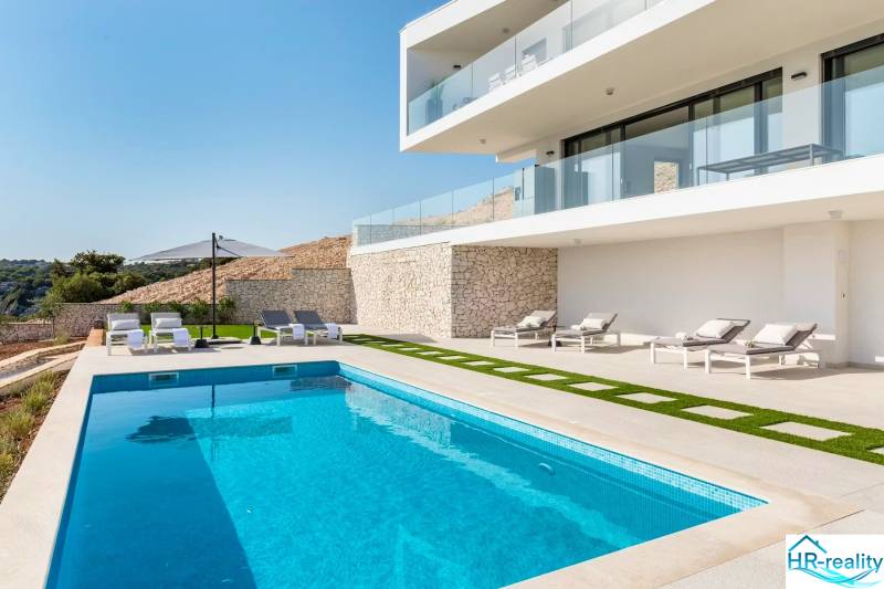 A recreational apartment in Rogoznica with a pool, sunbeds, and a terrace for relaxation.