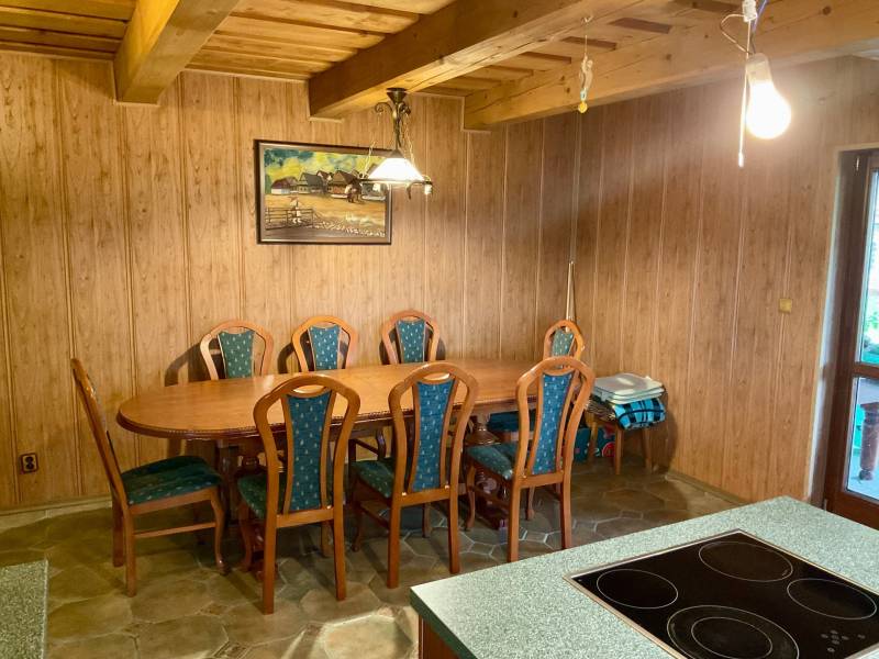 Interior with wooden decor, dining table and chairs, recreational grounds.